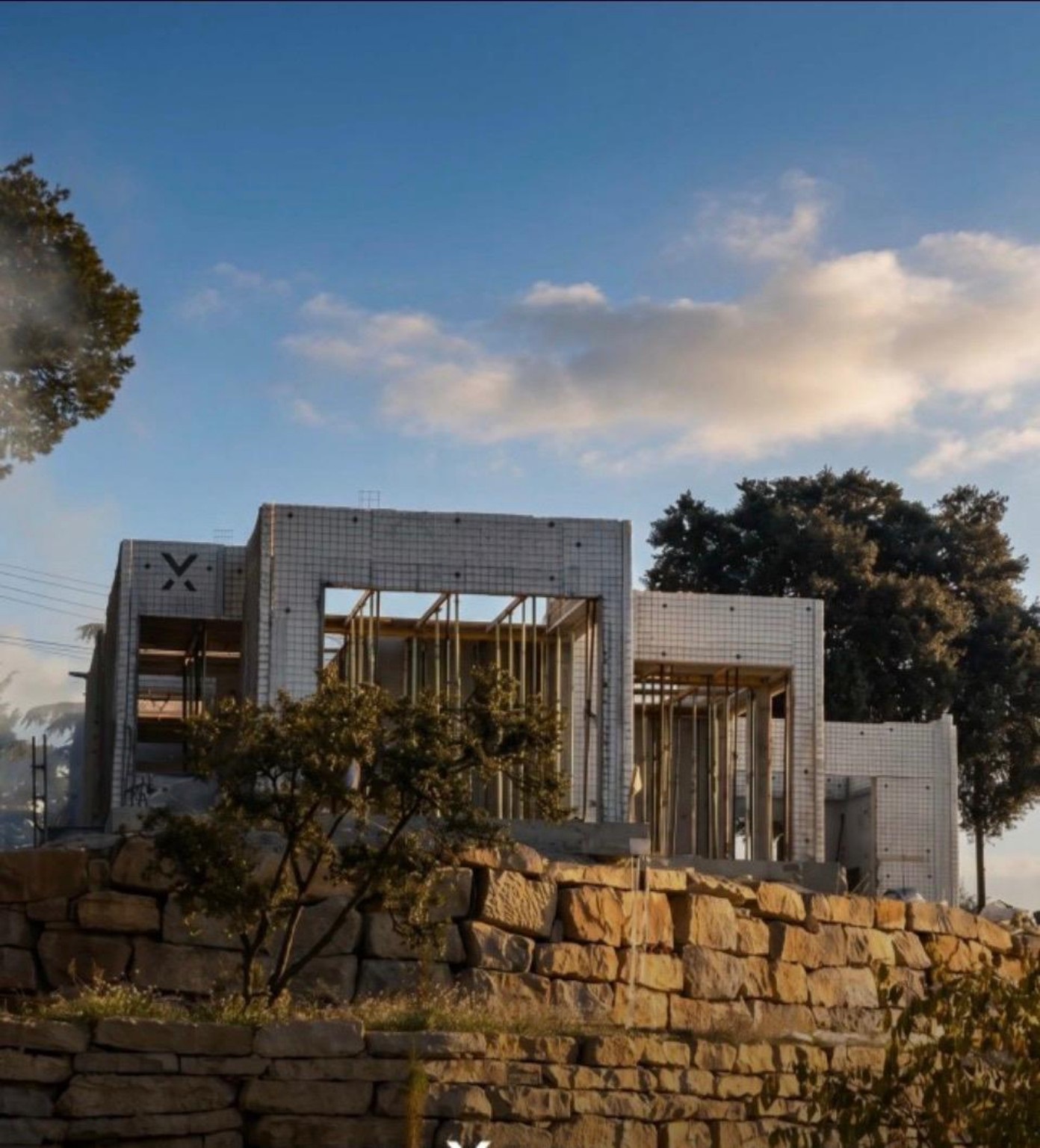 Vivienda Xpanel blanca sobre un muro de piedra en Barcelona